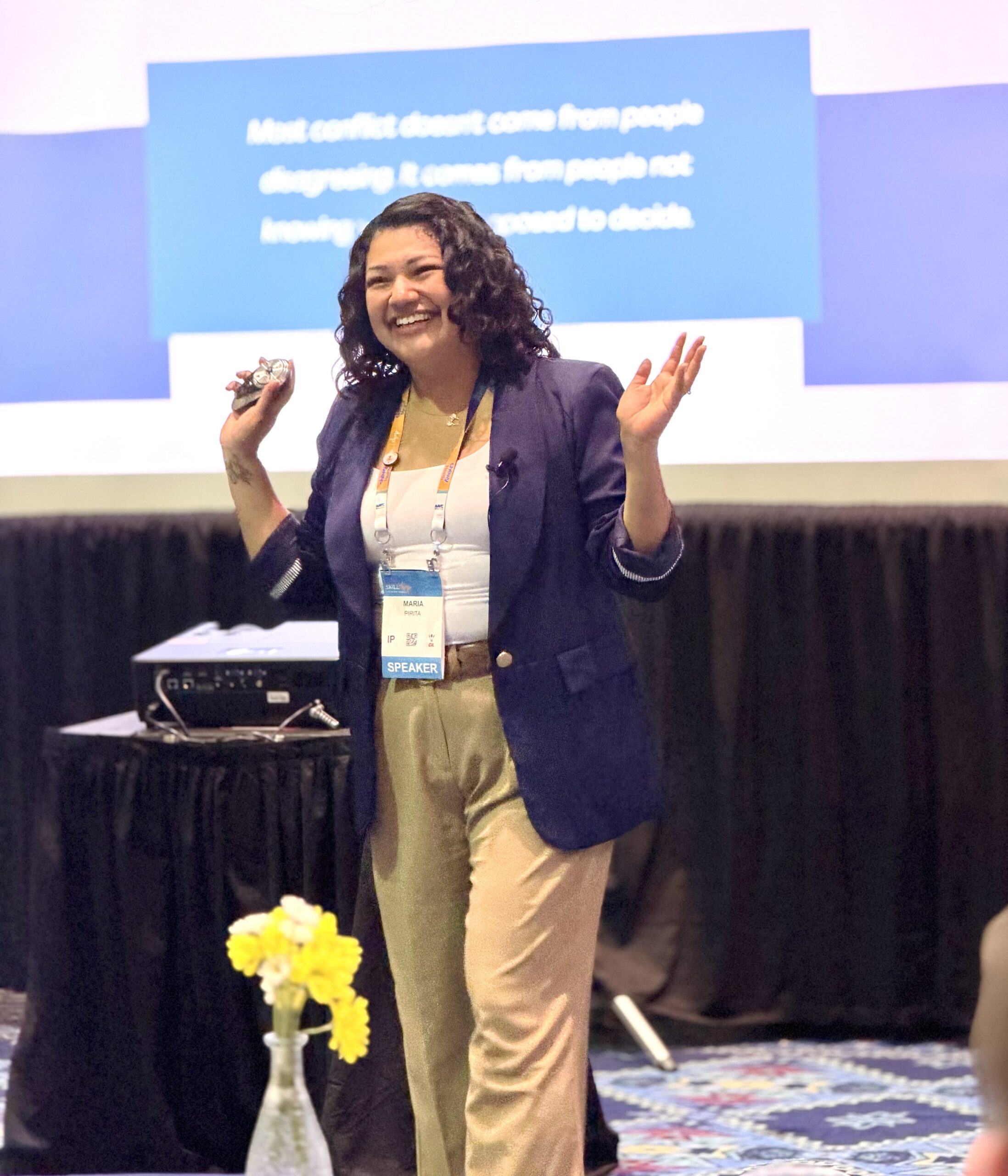 Maria Pirita laughing with the audience while speaking on stage